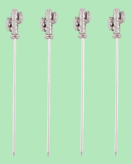 Four cactus-shaped cocktail picks on a light green background