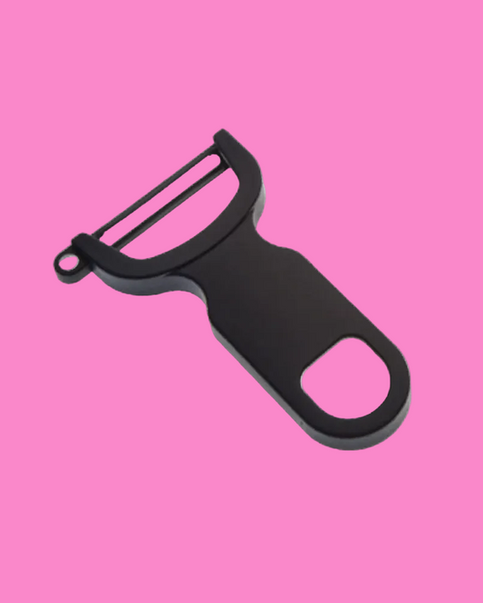 Black y-peeler on a pink background