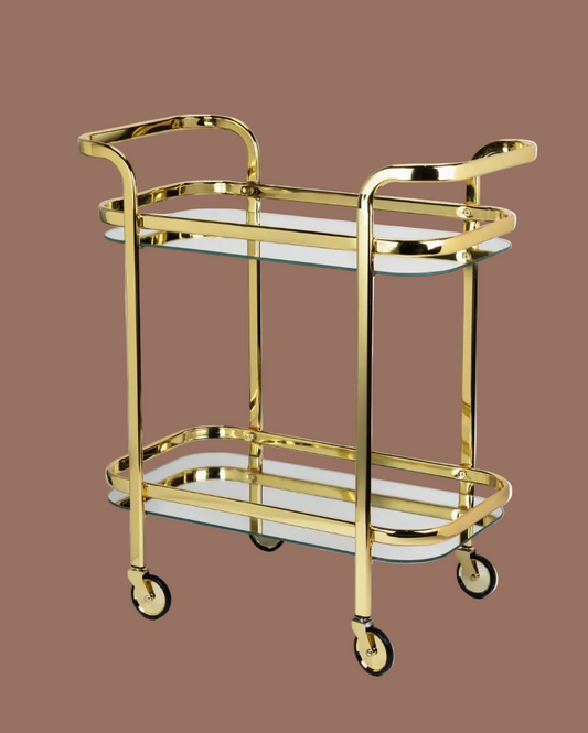 Gold serving cart with glass shelves on a brown background