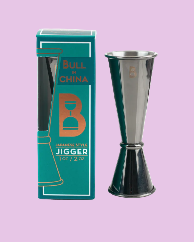 Metallic jigger with green packaging on a light purple background