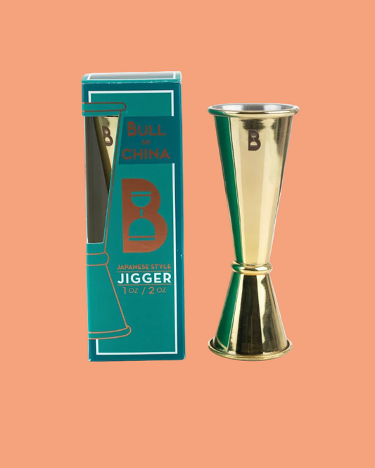Gold jigger with 'Bull Durham' packaging on a peach background