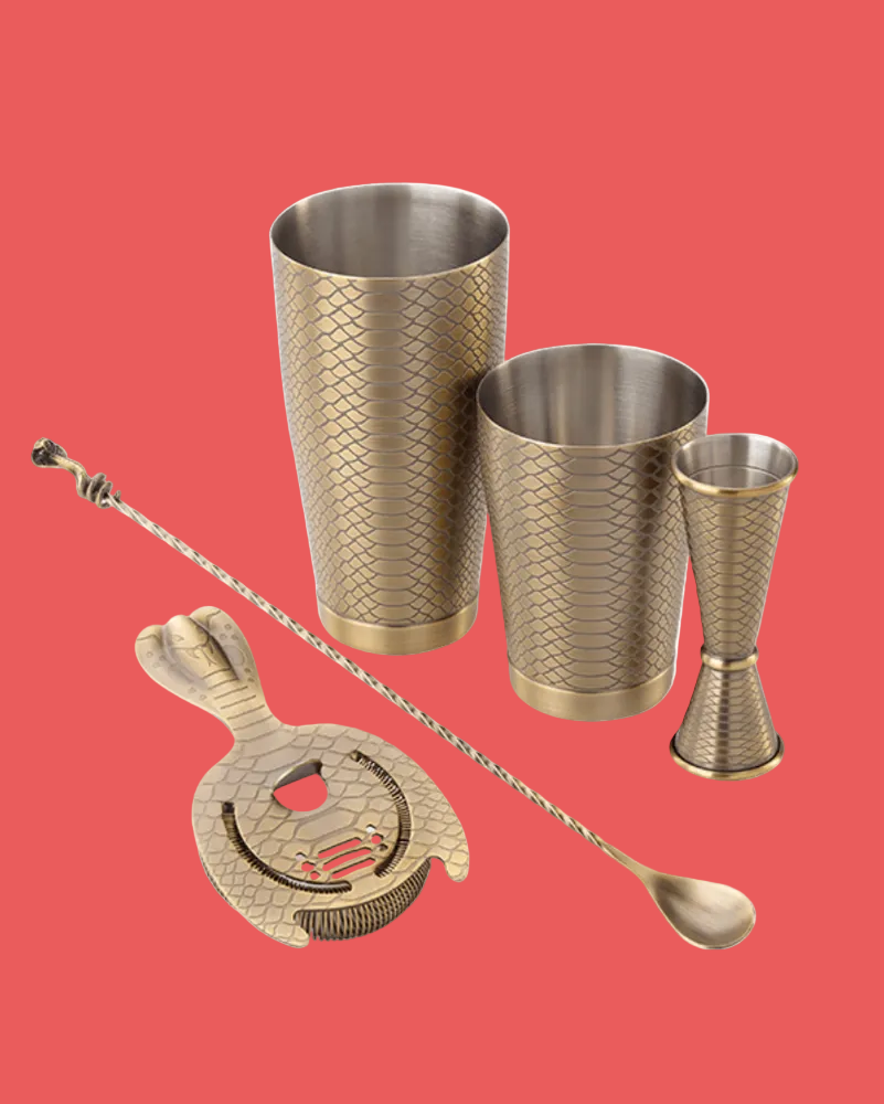Set of metallic cocktail shakers and tools on a white background