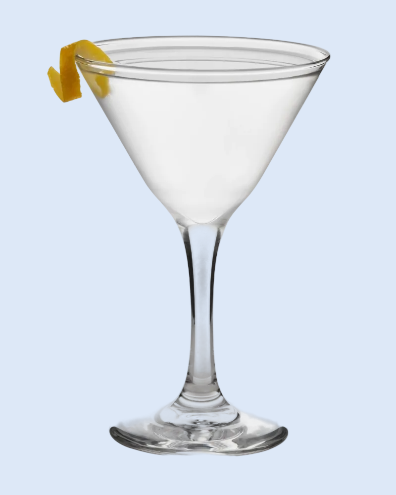 Clear martini glass with a lemon twist on a light blue background