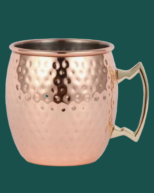 Copper mug with a handle on a green background