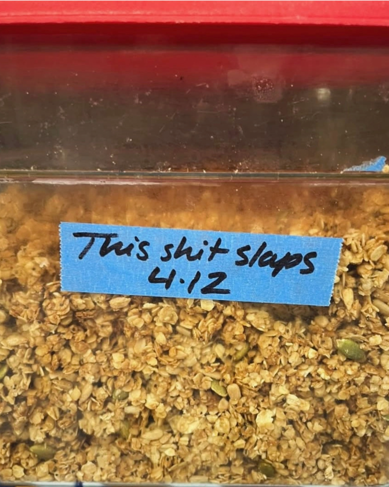 Container of food with a blue label reading 'This shit slaps 4/12' on a red background.