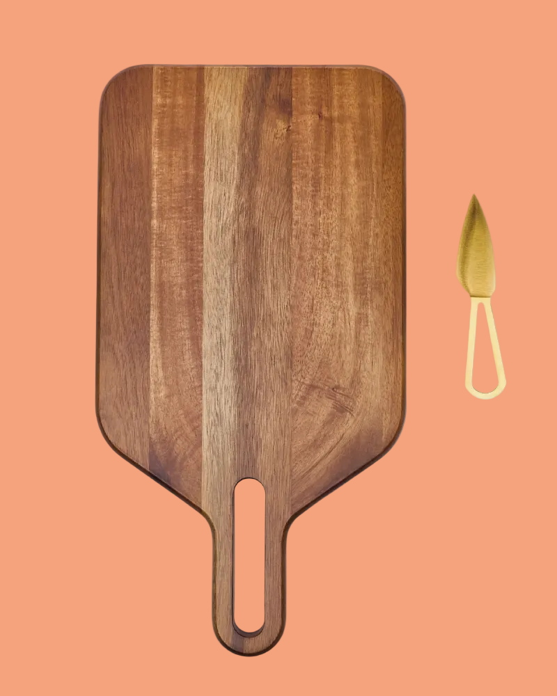 Wooden cutting board with a handle on a peach background