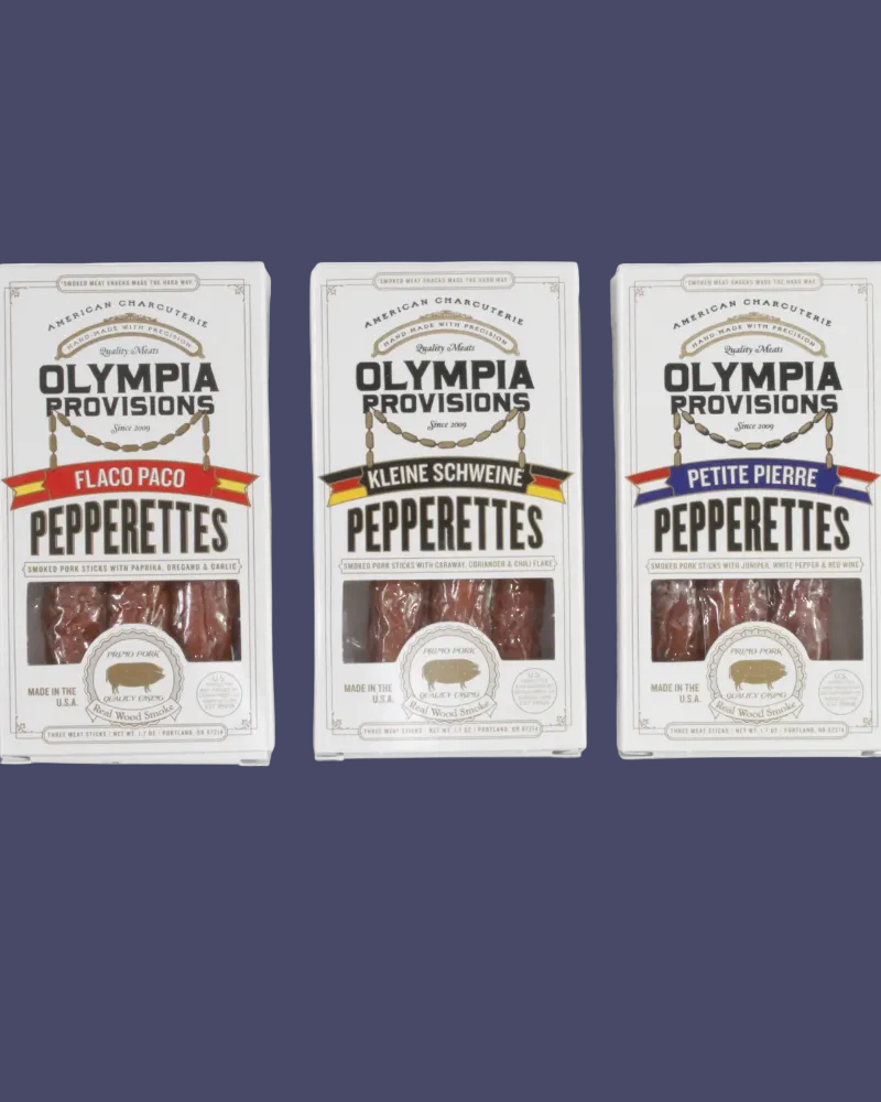 Three packages of Olympia Provisions Pepperettes on a white background
