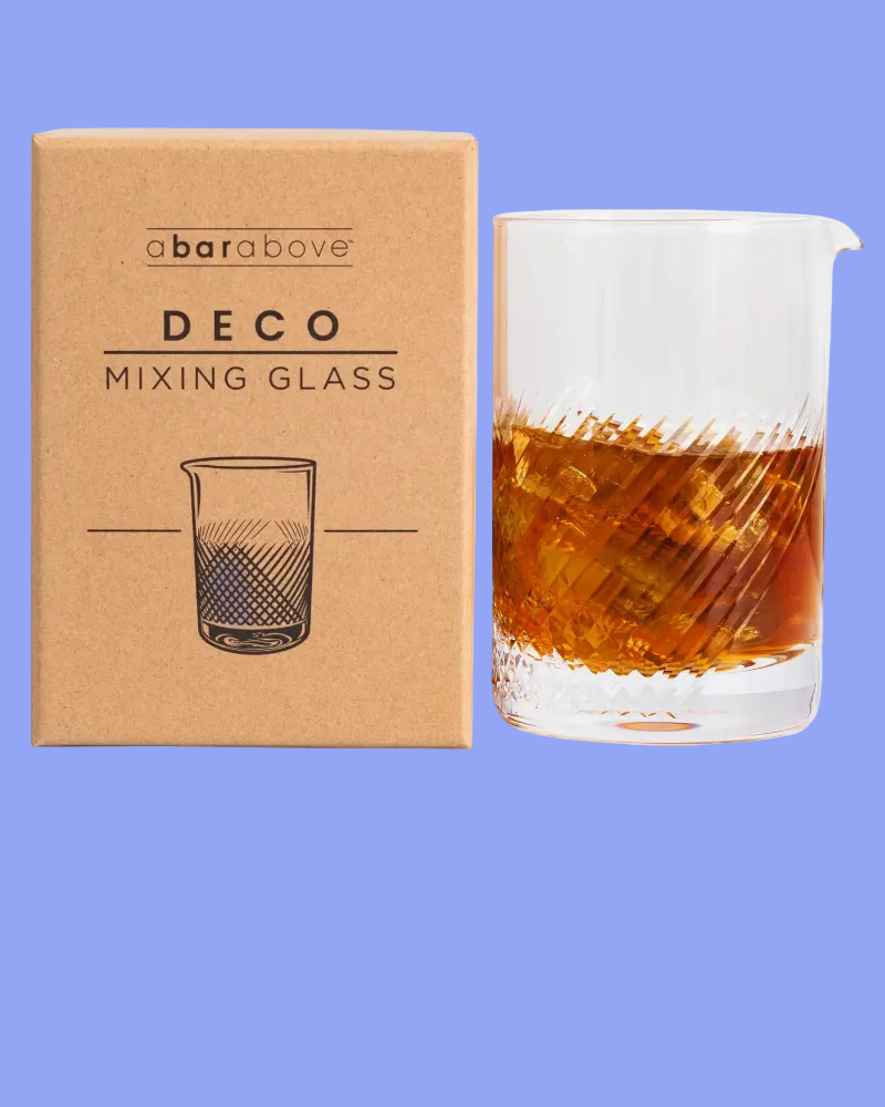 Deco mixing glass with a bar above branded box on a blue background