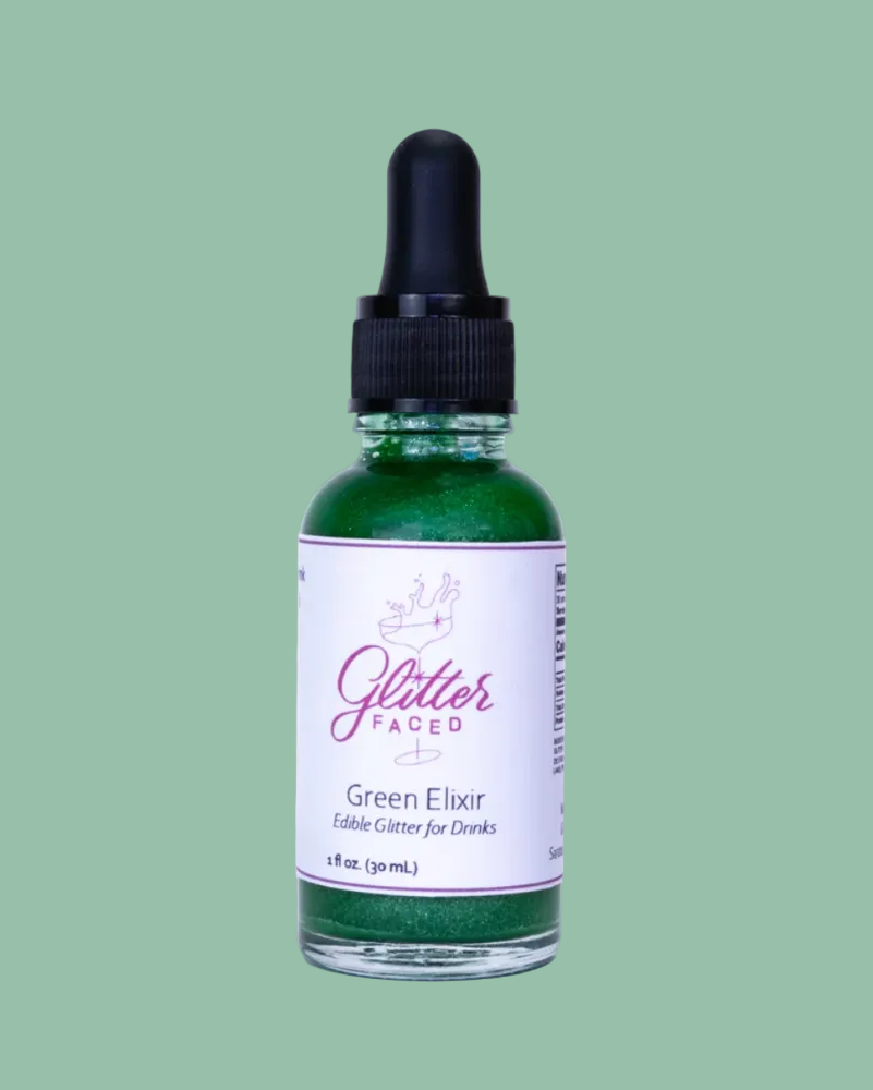 Bottle of Glitter Faced Green Elixir on a green background