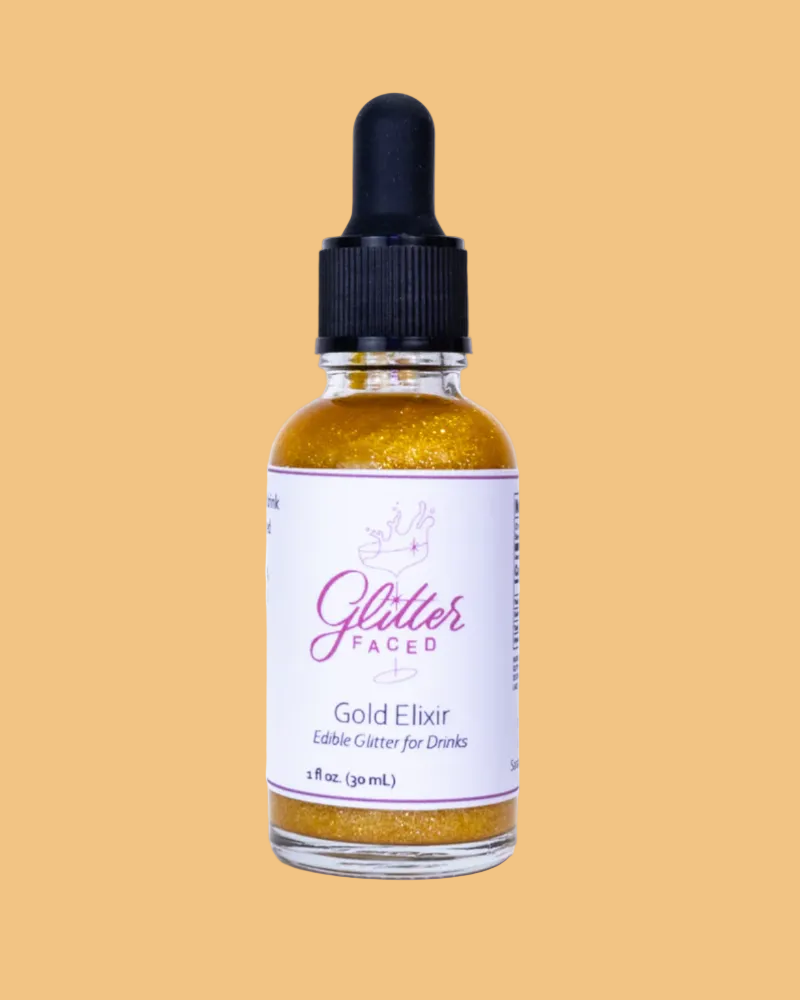 Bottle of 'Glitter Faced' Gold Elixir on a beige background