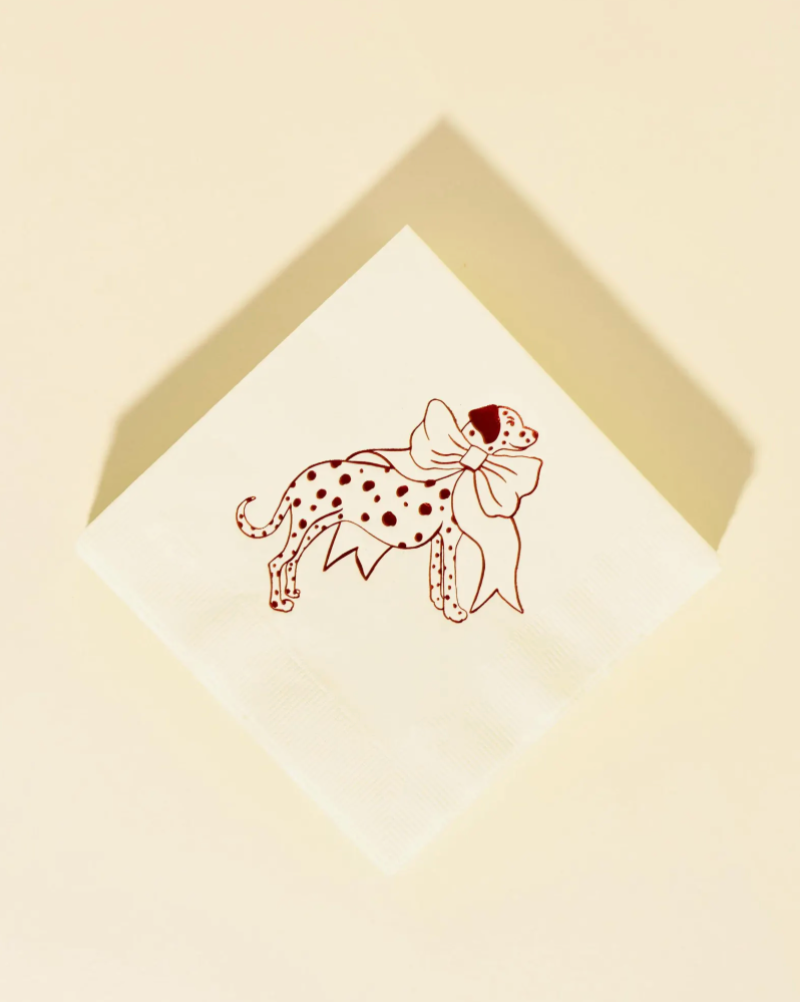 Dalmation with a bow illustration on a white card with a gold border, set against a beige background.