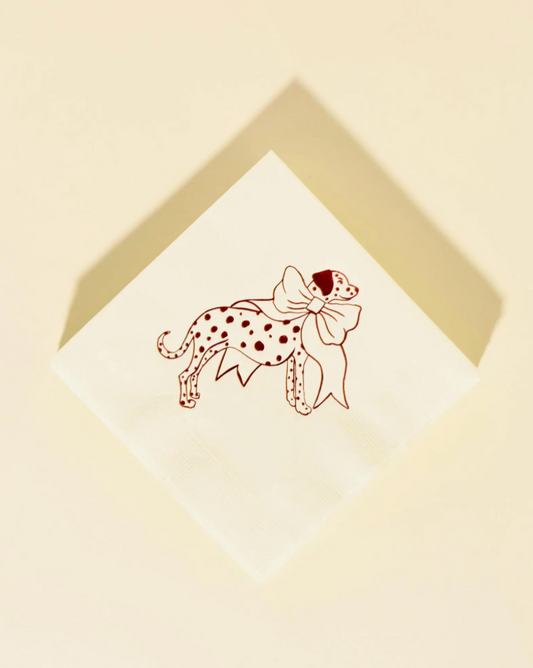 Dalmation with a bow illustration on a white card with a gold border, set against a beige background.