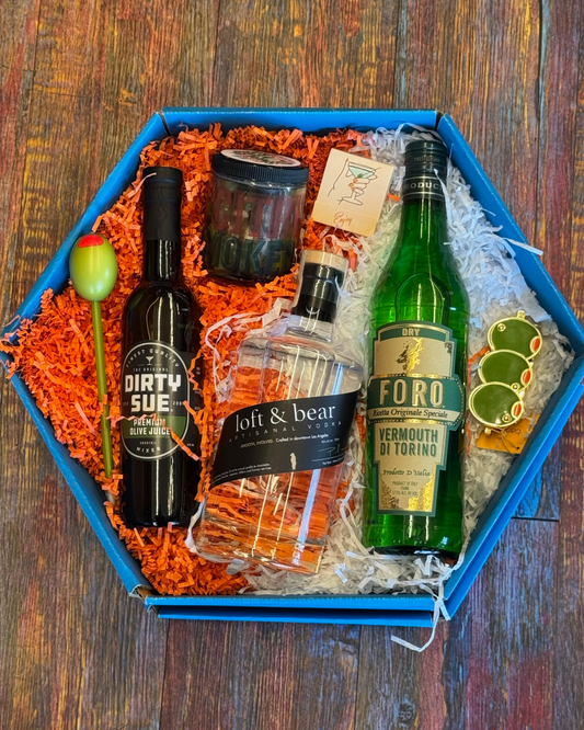 Gift box with bottles of alcohol and accessories on a wooden surface