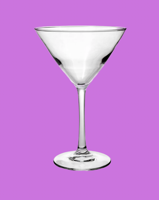 Clear martini glass on a purple background