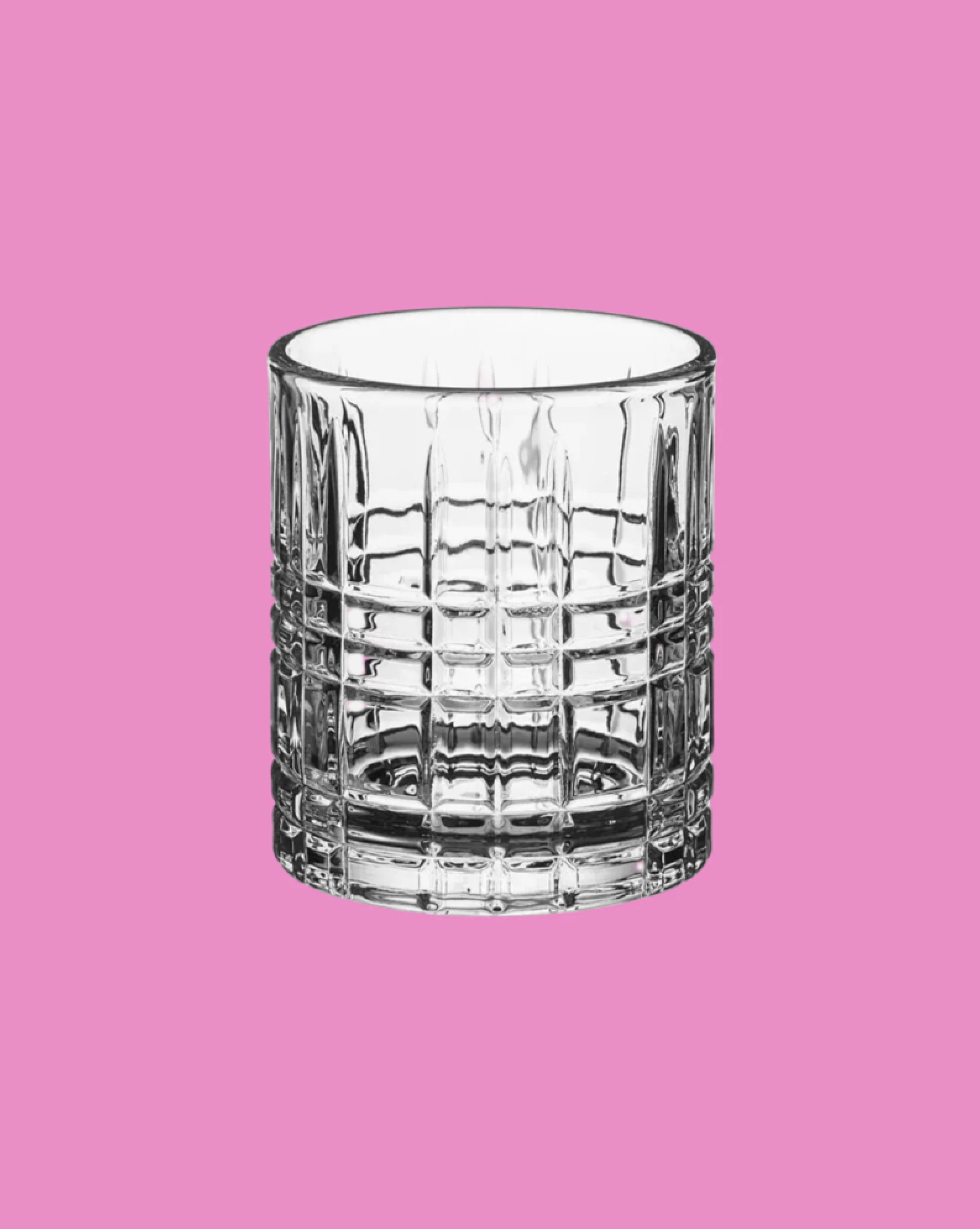 Clear glass tumbler on a pink background