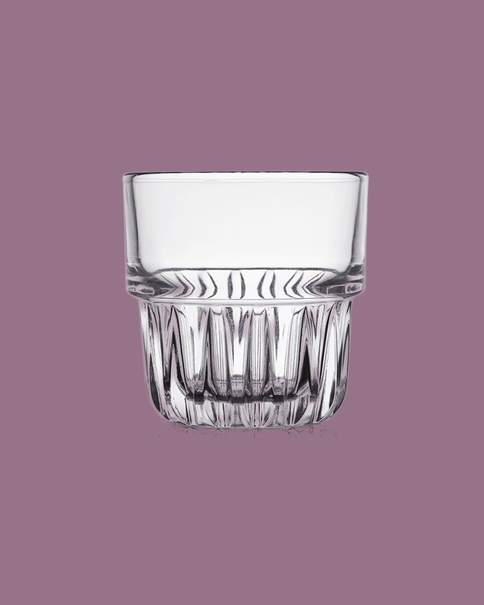 Clear glass tumbler on a purple background