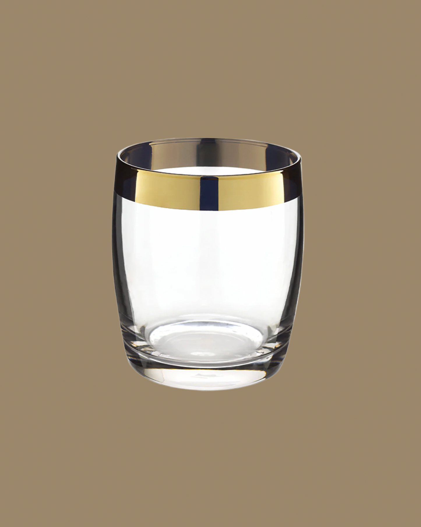 Clear glass tumbler with gold rim on a brown background