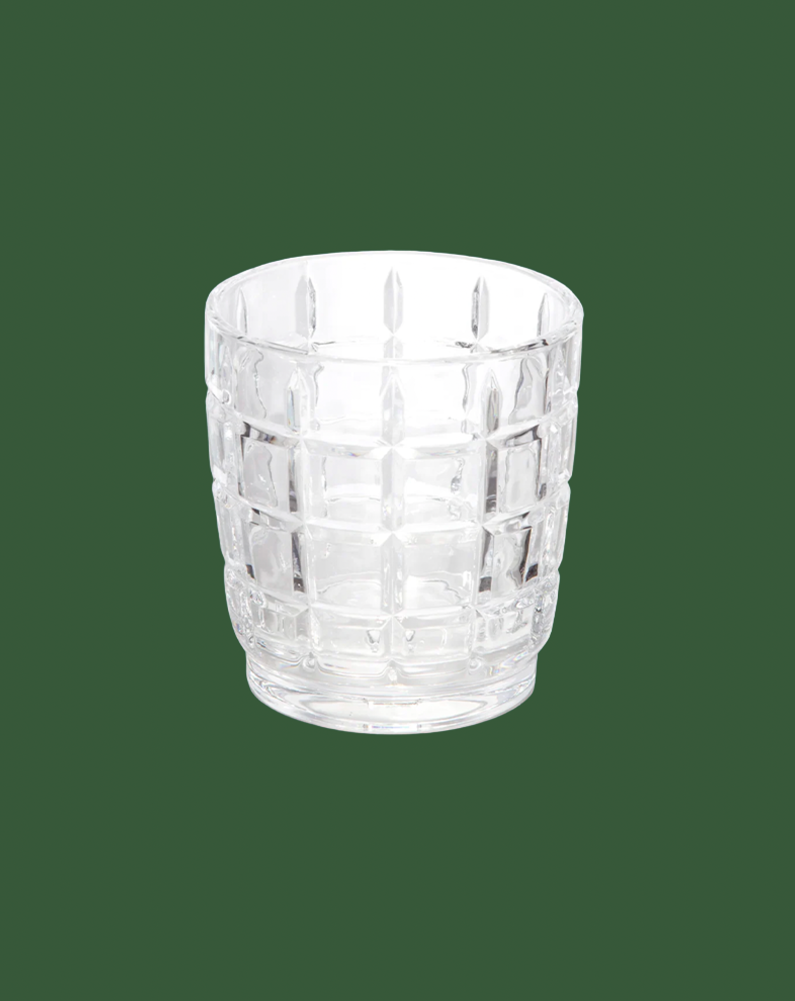 Clear glass tumbler with textured design on a green background