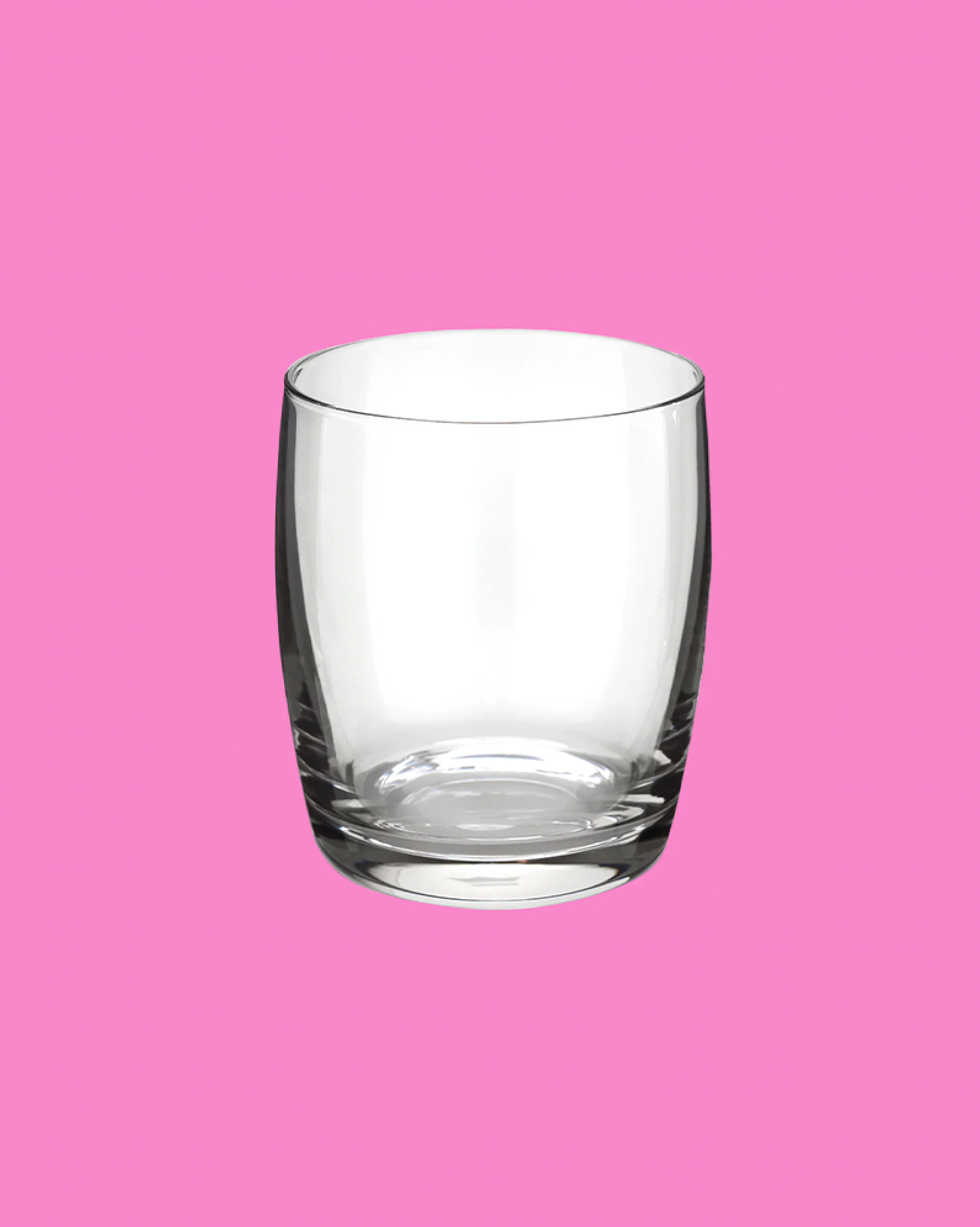 Clear glass tumbler on a pink background