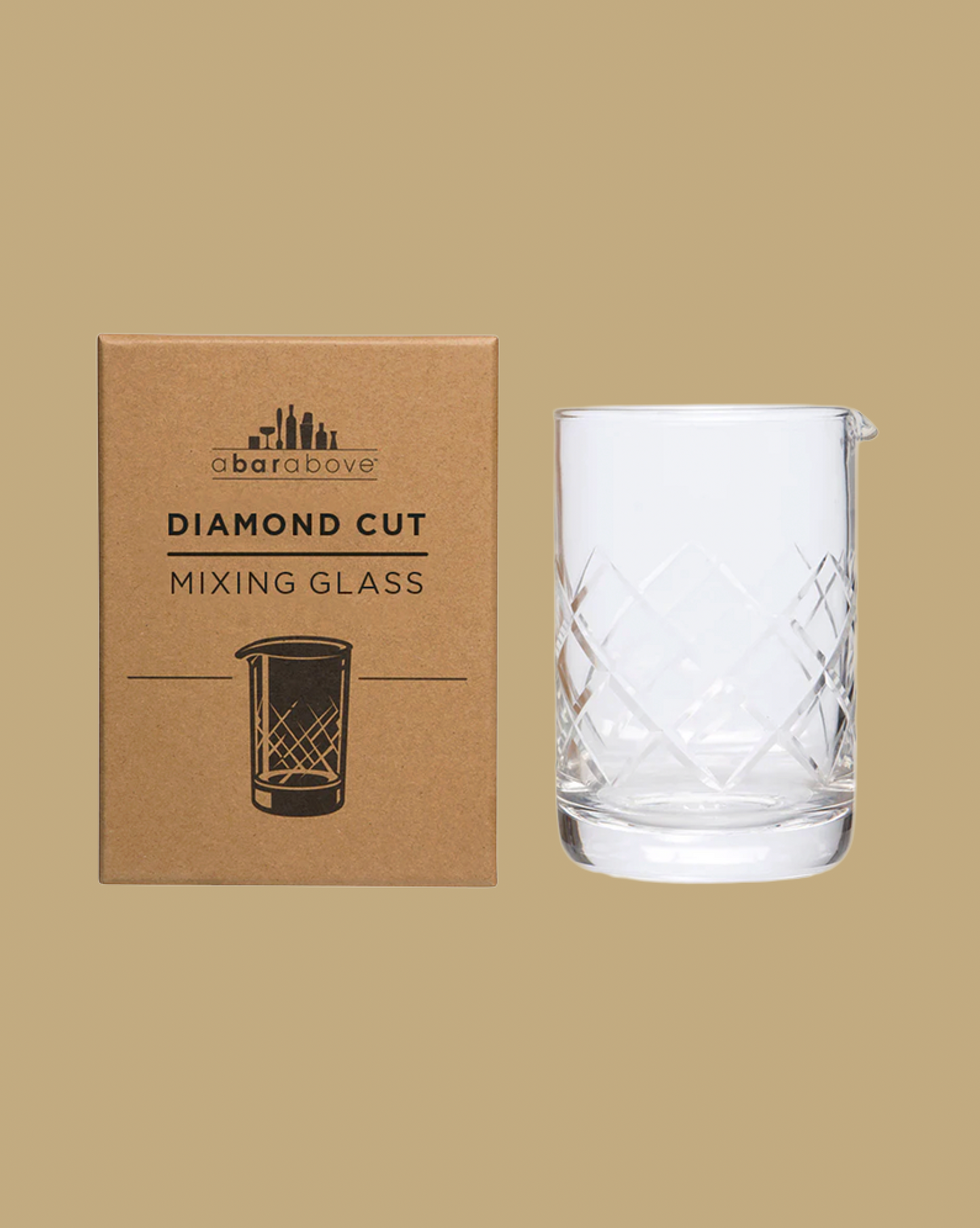 Diamond cut mixing glass with packaging on a beige background