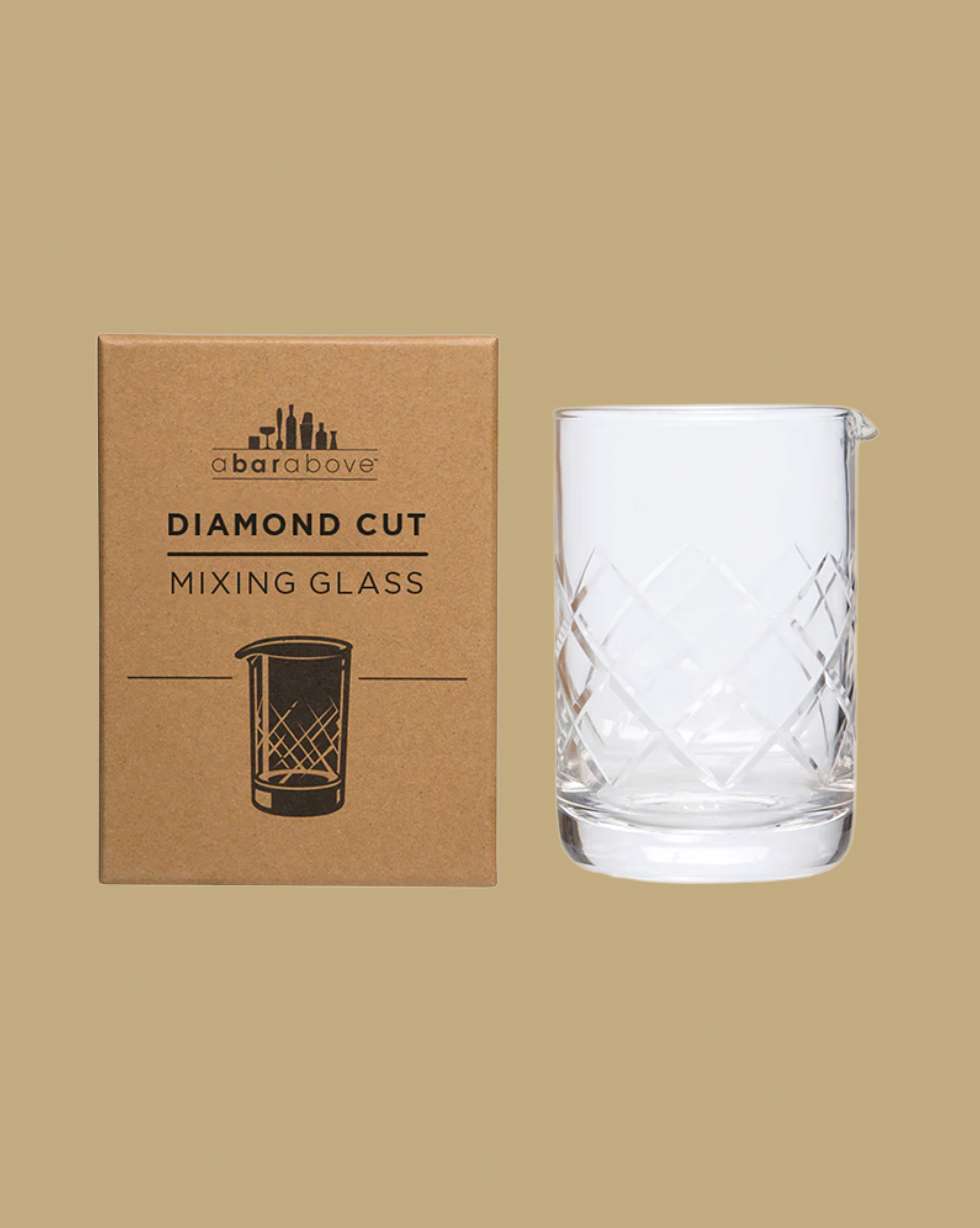 Diamond cut mixing glass with packaging on a beige background