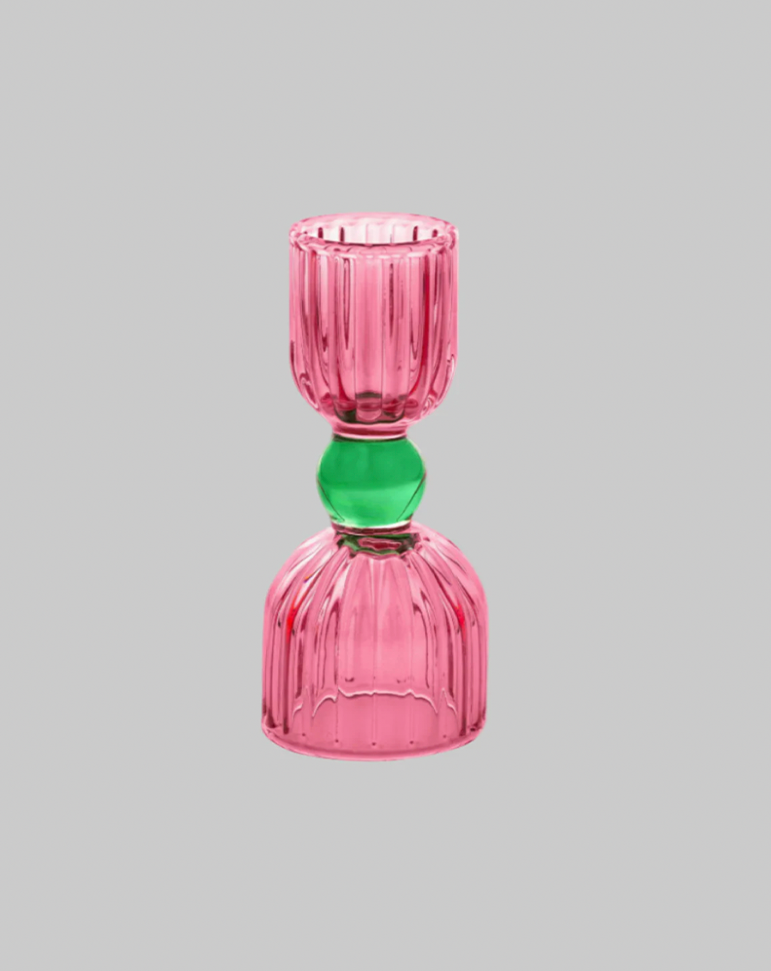 Pink glass candle holder with a green bead on a gray background