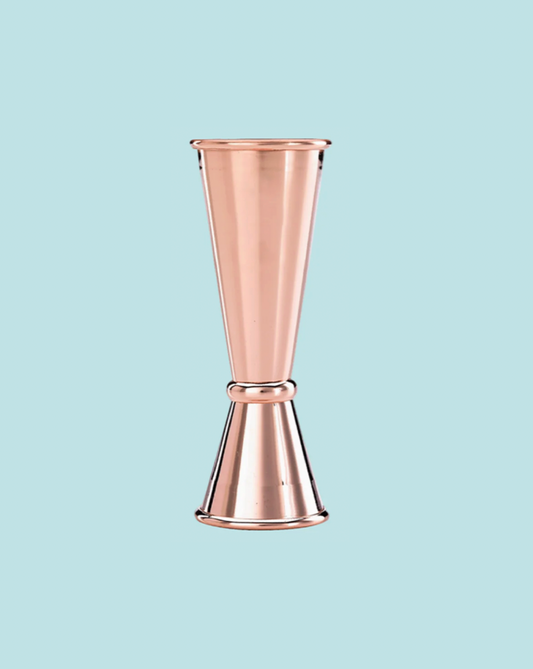 Copper jigger on a light blue background