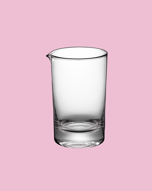Clear glass beaker on a pink background