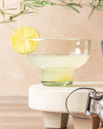 Cocktail glass with a lemon slice on a marble coaster with a blurred background