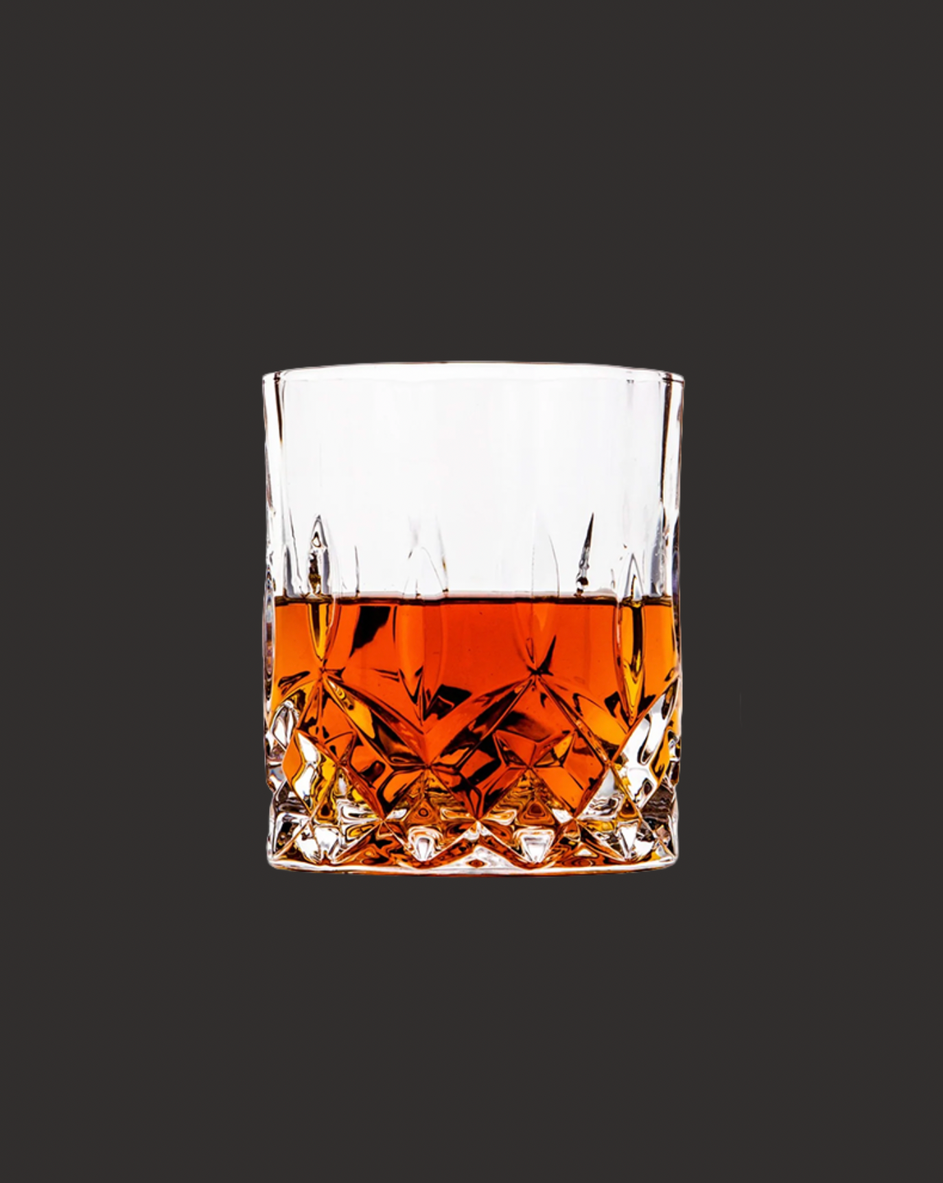 Crystal glass filled with amber liquid on a black background