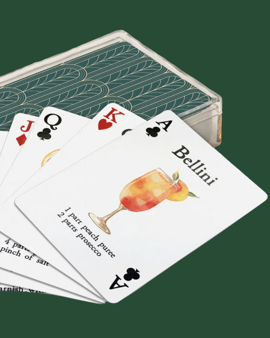 Playing cards with Bellini recipe on a white background