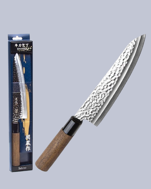Sakai knife with a textured blade and brown handle next to its packaging on a light gray background