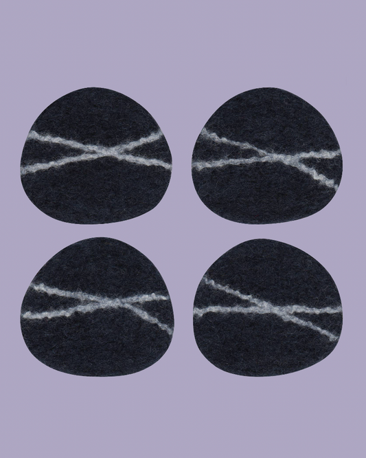 Four black circular patches with white stitching on a purple background