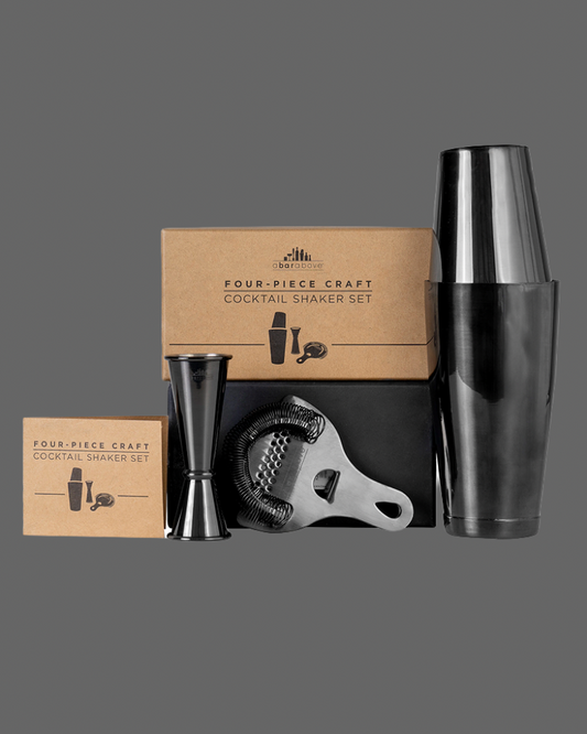 Four-piece craft cocktail shaker set with packaging on a gray background