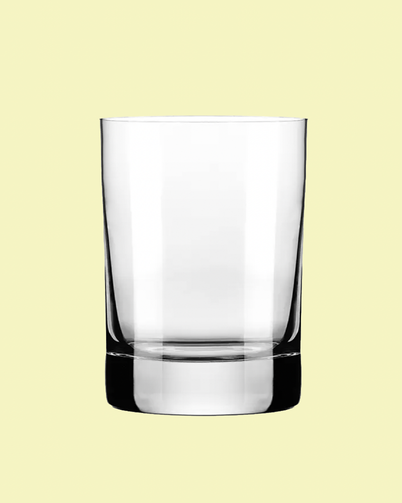 Clear glass tumbler on a light yellow background