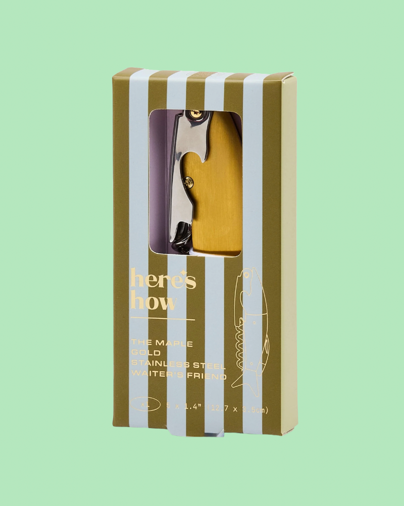 wooden corkscrew in striped box on green background