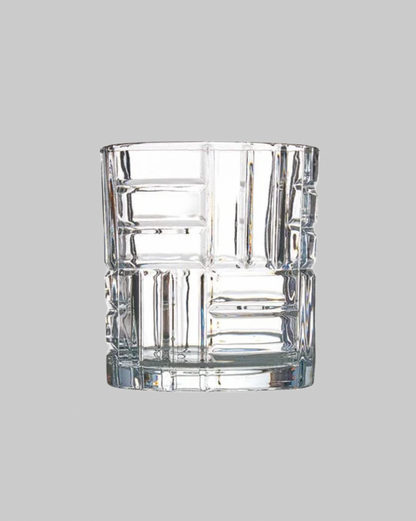 Clear glass tumbler with textured design on a gray background