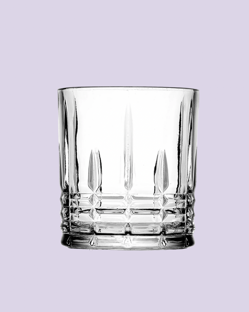 Clear glass tumbler with diamond pattern on a light purple background