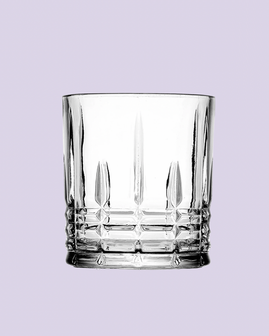 Clear glass tumbler with diamond pattern on a light purple background