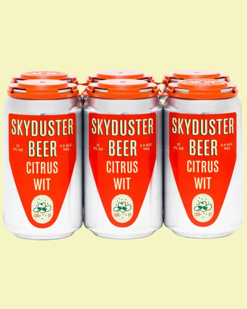 Three white aluminum cans of Skyduster Beer Citrus Wit with bright orange labels and orange lids, arranged side by side on a pale yellow background.