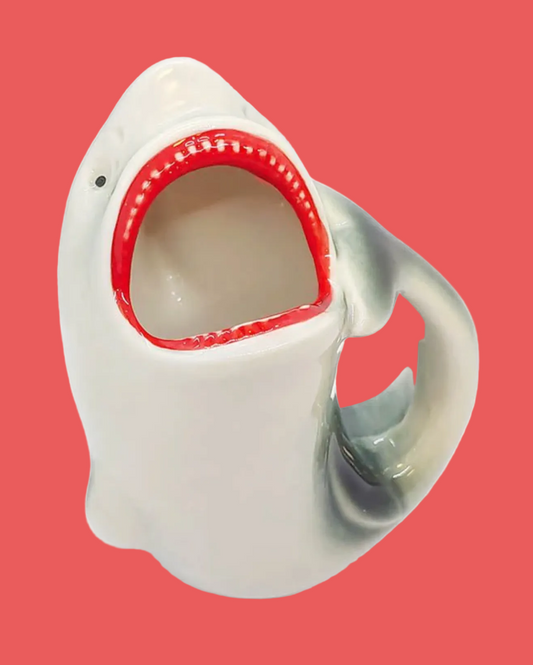 Shark-shaped mug with red interior on a pink background